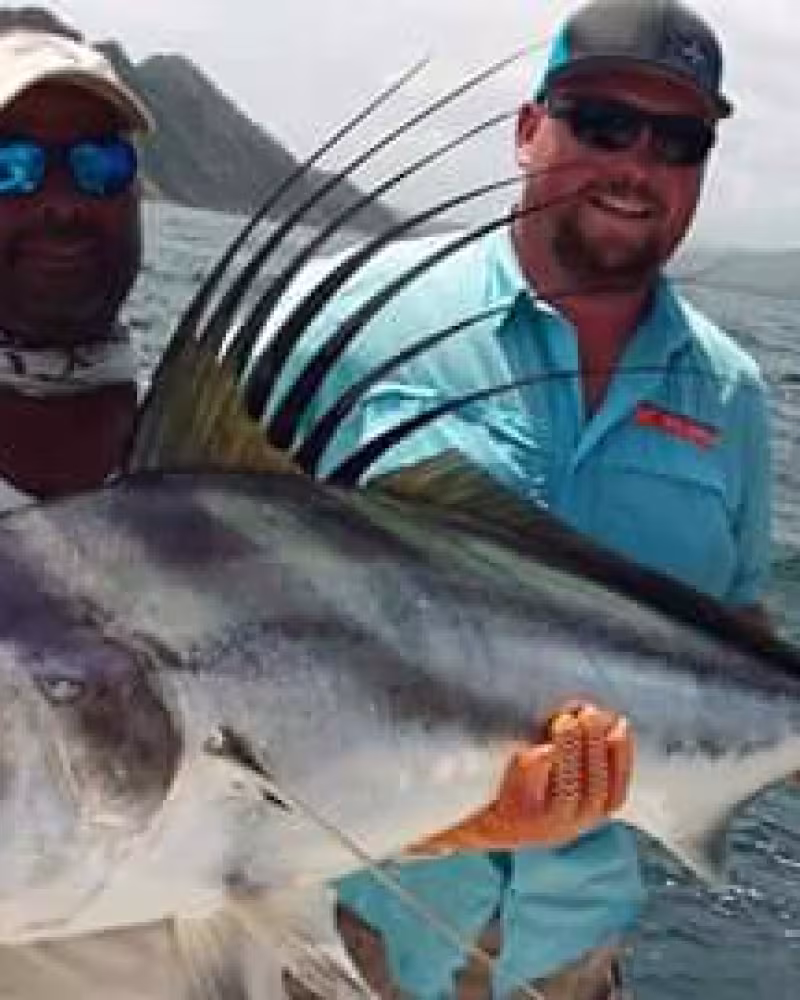 Happy fishing team celebrating a successful day with their catch on the boat.